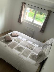 a white bed in a room with a window at gîte du parc du moulin du pré in Bavent +12 photos