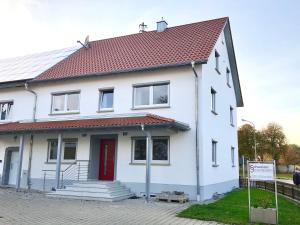 uma casa branca com um telhado vermelho em zollwanger - Wohnen auf Zeit em Dillingen an der Donau