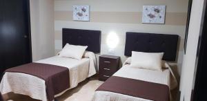 Łóżko lub łóżka w pokoju w obiekcie Hostal Málaga