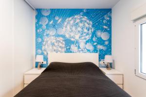 ein Schlafzimmer mit einem Bett und einer blauen Wand in der Unterkunft Calle San Carlos 132 in Alicante