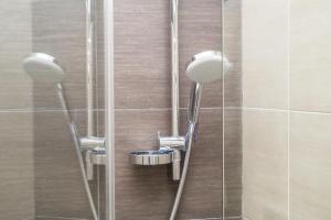 una doccia con 3 soffioni e una porta in vetro di Penta Luxury House a Roma
