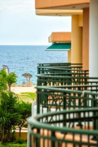 a green fence in front of a beach with the ocean at Mezonetes Toroni in Toroni