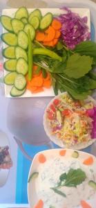 three plates of vegetables and a plate of dip at Aswan Nubian House in Aswan