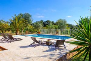a swimming pool with three chairs and a pool at Casa Calonge in Felanitx