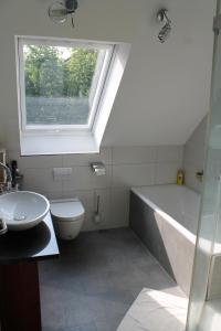 baño con bañera, lavabo y ventana en Gästezimmer 10 min von der Altstadt entfernt en Hattingen