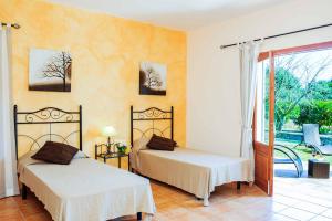 a bedroom with two beds and a door to a yard at Casa Calonge in Felanitx +13 photos