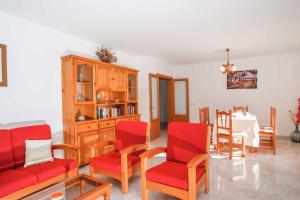 sala de estar con sillas rojas y mesa en Villa Punta des Port Catorce en Santanyí