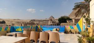 un gruppo di sedie di fronte a un muro con piramidi di Pyramids Overlook Inn a Il Cairo