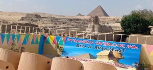 un cartello di fronte alle piramidi che lo guarda bed and breakfast di Pyramids Overlook Inn a Il Cairo