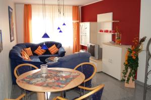 a living room with a table and a blue couch at Haus Siegfried Appartements in Xanten