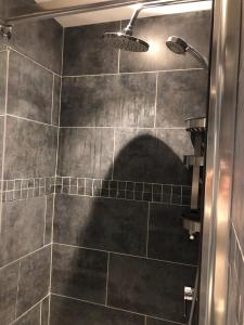 W łazience znajduje się prysznic z czarnymi kafelkami. w obiekcie Studio design proche Champs-Elysées w Paryżu
