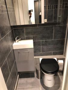 La salle de bains est pourvue de toilettes noires et d'un lavabo. dans l'établissement Studio design proche Champs-Elysées, à Paris