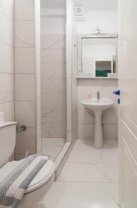 biała łazienka z toaletą i umywalką w obiekcie Sunset w miejscowości Agios Prokopios