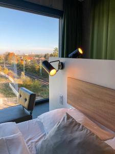 a bed room with a lamp and a window at gambino hotel CINCINNATI in Munich