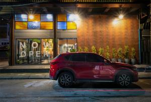 a red car parked in front of a store at BED Friends Poshtel in Chiang Rai