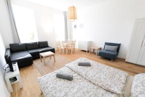 a living room with a couch and a bed at Vienna Living Apartments - Lerchenfelder Gürtel in Vienna