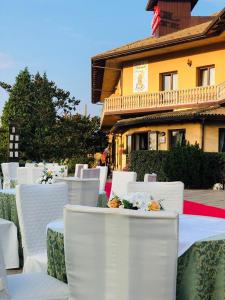 een groep witte stoelen en tafels met bloemen erop bij Hotel La Fontanella in Serra San Bruno