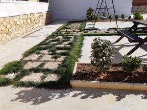 un jardín con césped, un banco y una mesa en Casa Rural la Veguilla, en La Almarcha