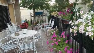 - une terrasse avec une table, des chaises et des fleurs dans l'établissement Casa Rural la Veguilla, à La Almarcha