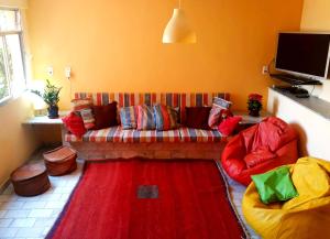 sala de estar con sofá y alfombra roja en Casa Babilonia, en Río de Janeiro