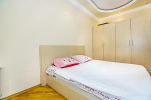 una camera da letto con un letto con cuscini rosa di Apartment in Boulevard a Baku