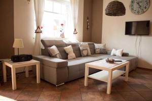 a living room with a couch and two tables at Ferienhaus Moorspatz, 95143 in Rhauderfehn