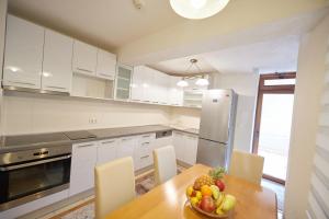 a kitchen with a table with a bowl of fruit on it at Grand Apartments-For Groups in Sarajevo