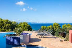 una piscina con sillas y vistas al agua en Alta Vista, en Artà