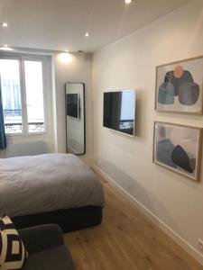 sypialnia z łóżkiem i telewizorem z płaskim ekranem w obiekcie Studio design proche Champs-Elysées w Paryżu