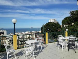 un patio con mesas y sillas en el balcón en Casa Babilonia, en Río de Janeiro