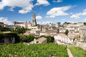 - une vue sur une ville avec une église et des bâtiments dans l'établissement Hôtel de Pavie, à Saint-Émilion