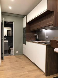 a kitchen with white and brown cabinets and a sink at Studio design proche Champs-Elysées in Paris