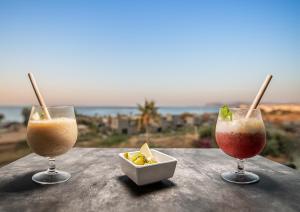 two glasses of drinks on a table with a view at Sea View Hotel & Apartments in Kato Daratso