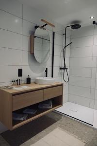 een badkamer met een wastafel en een douche bij Le Grand George - Résidence Le Cercle in Marche-en-Famenne