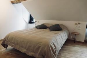 een bed met twee kussens in een slaapkamer bij Le Grand George - Résidence Le Cercle in Marche-en-Famenne
