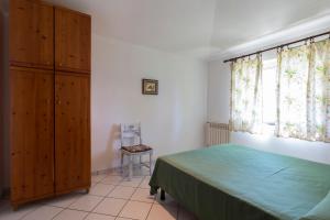 ein Schlafzimmer mit einem Bett, einem Stuhl und einem Fenster in der Unterkunft Villa Aurelia in Ioppolo