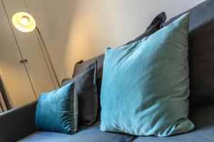 two blue pillows sitting on a couch with a lamp at Apartment Iris 4 in Chamonix