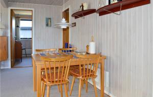 uma cozinha com uma mesa de madeira e cadeiras em Stunning Home In Hadsund With House Sea View em Hadsund