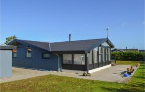 uma casa com um telhado azul e um quintal em Stunning Home In Hadsund With House Sea View em Hadsund
