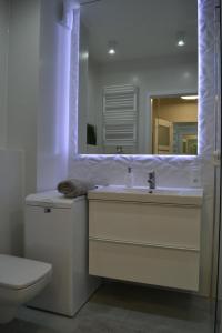 ein Badezimmer mit einem Waschbecken, einem WC und einem Spiegel in der Unterkunft Stella del Mare 4 in Władysławowo