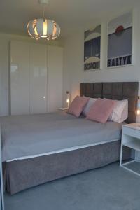 ein Schlafzimmer mit einem großen Bett und einem Kronleuchter in der Unterkunft Stella del Mare 4 in Władysławowo