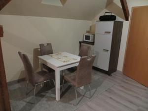 ein Esszimmer mit einem weißen Tisch und Stühlen in der Unterkunft Ferienwohnung & Zimmervermietung Wolf in Bad Frankenhausen