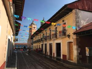 une rue aux drapeaux et un bâtiment avec une tour d'horloge dans l'établissement Cabaña Familiar en Centro Real del Monte, à Mineral del Monte