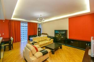 a living room with a couch and a table at Red Apartment Vip City Center in Baku