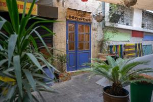 a blue door on a building with plants in front at The Cabin in Amman