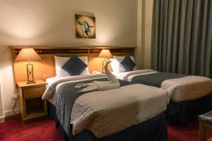 מיטה או מיטות בחדר ב-Kindi Suite Hotel