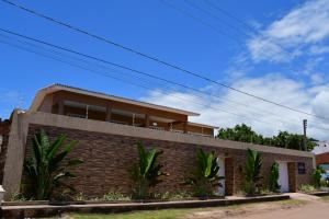 a brick house with palm trees in front of it at Casa de Praia Pouso das Fadas com Arrumadeira e Equipe de Cozinha in Maragogi
