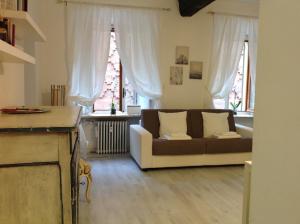a living room with a couch and two windows at Madama Suite in Turin