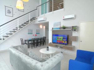 un salon avec un canapé, une télévision et une table dans l'établissement Maritime Suites by Comfy, à George Town