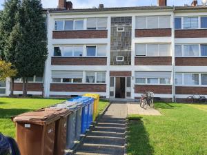 uma fila de latas de lixo em frente a um edifício em Ferienwohnung Linden em Willich